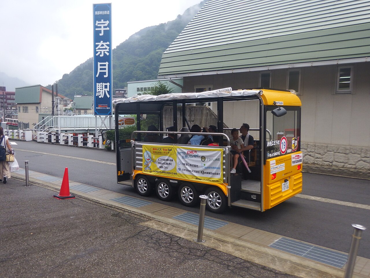 山裾の湯町を見下ろし、川岸に沿って伸びる橋と朝の湯気